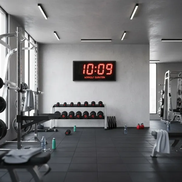 A large, highly visible gym wall clock mounted in a clean, organized fitness space.