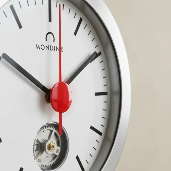 Close-up of Mondaine Stop2Go clock with red second hand paused at 12 o'clock, minute hand advancing