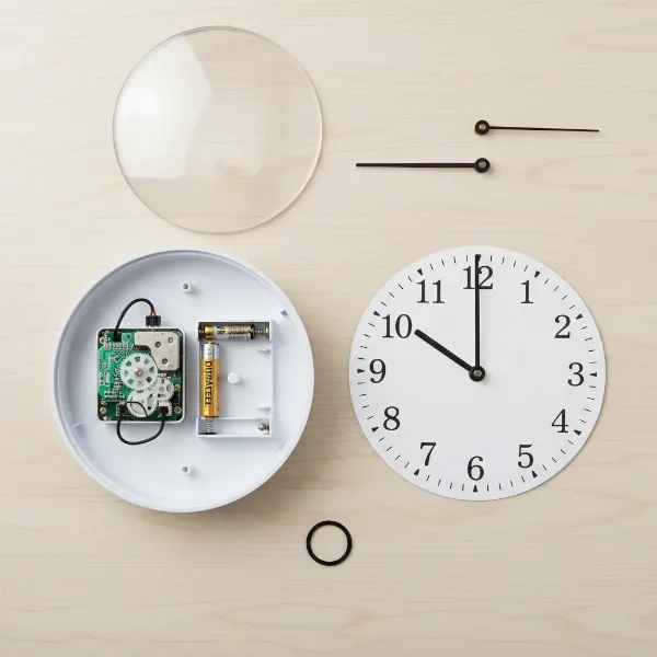 Detailed view of a disassembled wall clock showing its internal components for recycling guide.